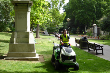 A member of staff using a ride on mower in Victoria Embankment Gardens